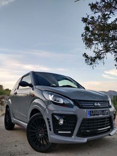 a silver car parked on top of a dirt road