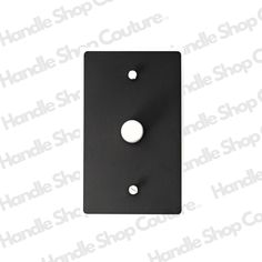 a black switch plate with two white knobs on the front and one in the back