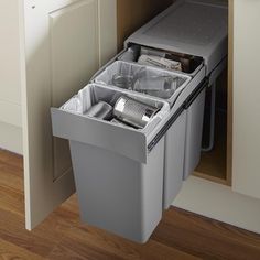 an open trash can in the corner of a kitchen cabinet next to a counter top