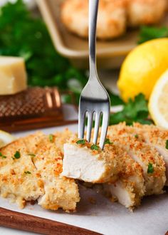 a piece of chicken with parmesan cheese on it and a fork in the middle