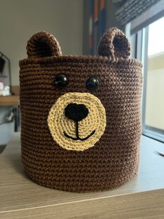 a crocheted brown bear basket sitting on top of a table