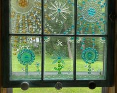 a window that has some glass beads on the windowsills and is decorated with flowers