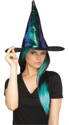 a woman with long blue hair wearing a witches hat and black t - shirt is posing for the camera