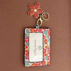 a keychain with a flower on it hanging from a wall