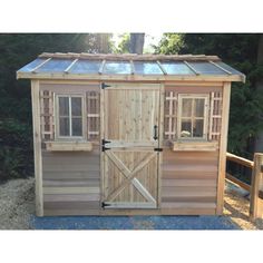 a small wooden shed with doors and windows