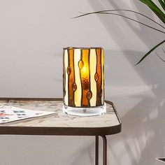 a table with a lamp on it next to a potted plant