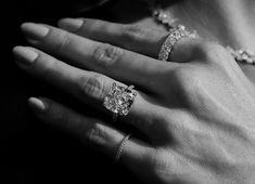 a woman's hand with two diamond rings on her left and one ring on her right