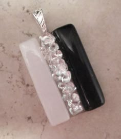 a black and white object with crystal beads on it's side sitting on a table