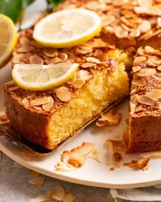 a lemon almond cake on a plate with slices cut out and ready to be eaten