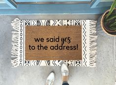 a person standing in front of a door with a welcome mat on the floor that says, we said yes to the address