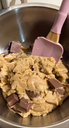 a mixing bowl filled with batter and chocolate chunks