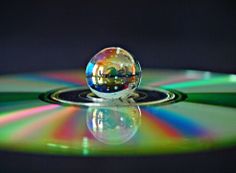 a cd that is sitting on top of a table with it's reflection in the disc