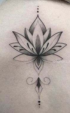 a woman's back with a lotus tattoo on it