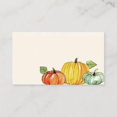 three pumpkins with leaves on them sitting next to a white card that says, happy thanksgiving