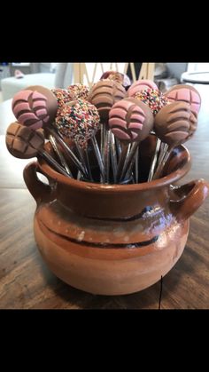 there are many chocolate covered candies in a vase on the table, with sprinkles sticking out of them