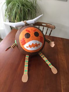 a paper mache sitting on top of a wooden table next to a potted plant