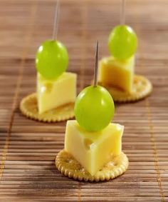 small crackers with cheese and green grapes on them