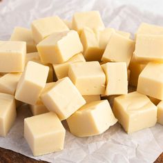 a pile of cubed cheese sitting on top of a piece of wax paper