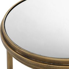 a round mirror sitting on top of a wooden table