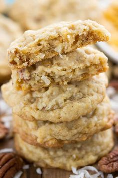 three cookies stacked on top of each other with pecans in the background and one cookie half eaten