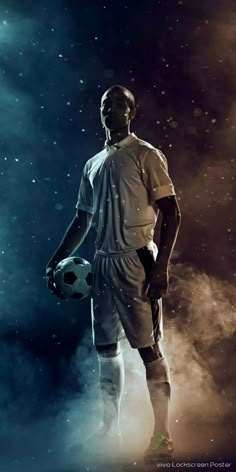 a man holding a soccer ball on top of a foggy field with stars in the sky