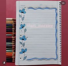 an open notebook with writing on it next to colored pencils