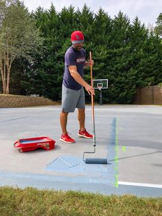 a man standing on top of a basketball court next to a red bucket and net