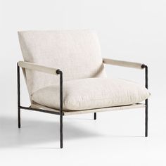 a white chair with black metal legs and a beige upholstered cushion on the back