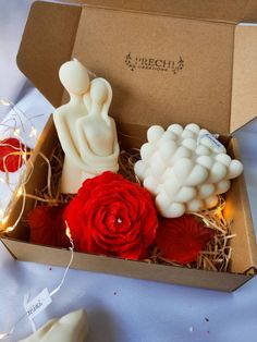 a box filled with candles and flowers on top of a table