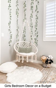 a bedroom decorated in white with green plants on the wall and a hammock bed