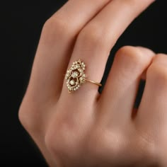 a woman's hand wearing a gold ring with diamonds on the top and bottom