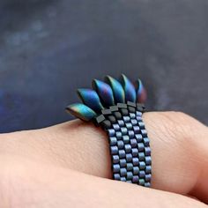 a person's hand with a ring made out of black and blue material on it