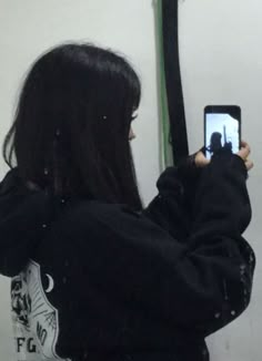 a woman taking a selfie in front of a mirror