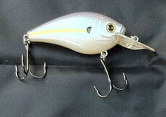 a white fishing lure sitting on top of a blue cloth