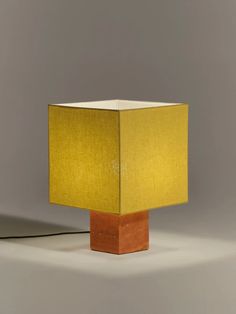 a wooden block with a yellow lamp on it