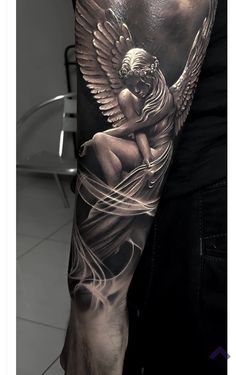 a man's arm with an angel tattoo on it and the image of a woman holding