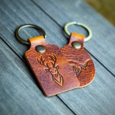 two leather keychains with deer heads on them