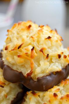 three chocolate covered donuts are stacked on top of each other with coconut sprinkles