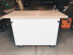 a kitchen island made out of wood on wheels