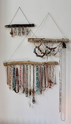 two wall hangings with various necklaces on them