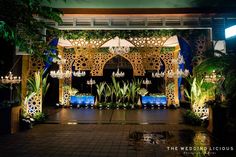 an outdoor wedding venue decorated with blue and white flowers, greenery and chandeliers