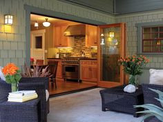 an outdoor living area with wicker furniture and potted plants