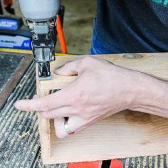 a person using a drill to cut wood