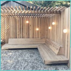 a wooden bench sitting in the middle of a yard next to a fence with lights on it