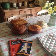 two muffins sitting on top of a table next to a book and flowers