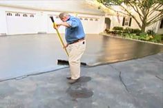 an older man is cleaning the driveway with a broom