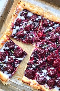 berry tart with cream on top sitting in a baking pan, ready to be eaten