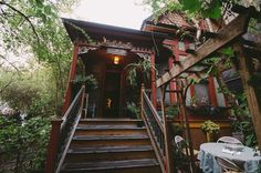 an outdoor dining area with stairs leading up to the house