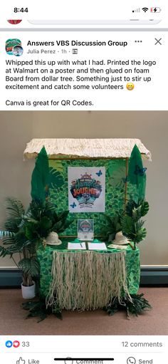 a table with some plants on it and an advertisement for the event in front of it