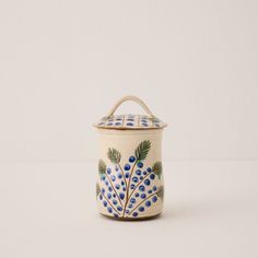 a blue and white pot with a handle on the top is sitting on a table